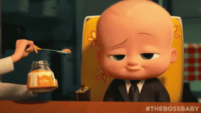 A Baby From The Boss Baby Sits At A Table With A Jar Of Honey GIF