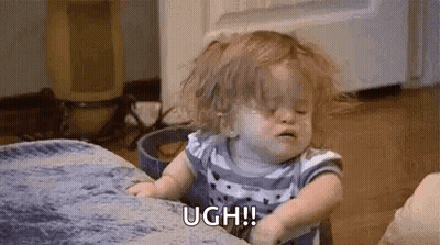 A Baby Girl Is Sitting On A Couch With Her Eyes Closed And Crying . GIF
