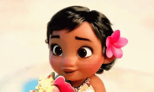 A Baby Girl With A Flower In Her Hair Is Holding A Seashell . GIF