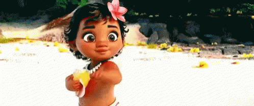 A Baby Girl With A Flower In Her Hair Is Standing On The Beach Holding A Banana . GIF