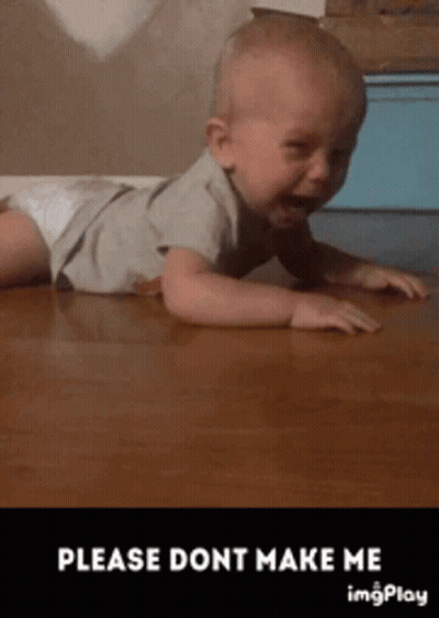 A Baby In A Diaper Is Crawling On A Wooden Floor . GIF
