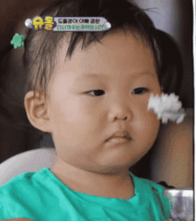 A Baby In A Green Shirt Is Eating Rice GIF