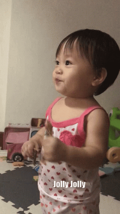 A Baby In A Pink And White Tank Top With The Word Jolly On It GIF