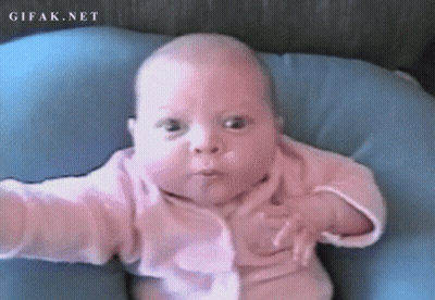 A Baby In A Pink Shirt Is Laying On A Blue Pillow With Gifak.net Written On The Bottom Right GIF