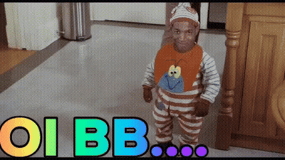 A Baby In A Striped Outfit Is Standing In Front Of A Sign That Says Oi Bb On It GIF