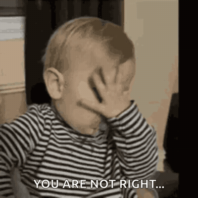 A Baby In A Striped Shirt Is Covering His Face With His Hand . GIF