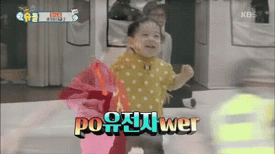 A Baby In A Yellow Polka Dot Shirt Stands In Front Of A Kbs Logo GIF
