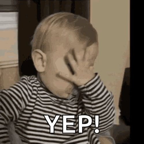 A Baby Is Covering His Face With His Hand And Saying Yes . GIF