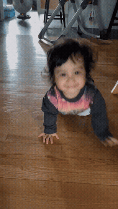 A Baby Is Crawling On The Floor Wearing A Shirt That Says ' Spiderman ' On It GIF