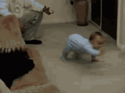 A Baby Is Crawling On The Floor While A Man Looks On GIF