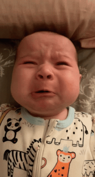 A Baby Is Crying And Wearing A Zebra And Elephant Onesie GIF