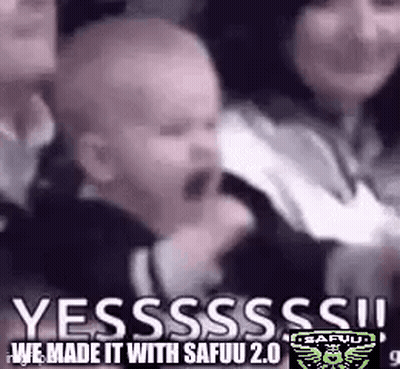 A Baby Is Crying In A Crowd Of People While A Woman Holds Him . GIF