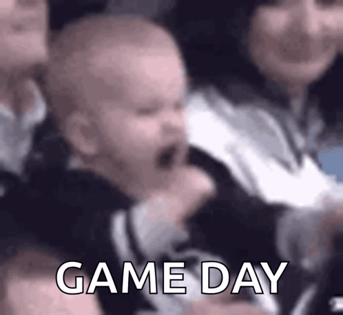 A Baby Is Crying While Sitting In A Crowd Of People And The Words Game Day Are Visible . GIF