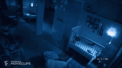 A Baby Is Laying In A Crib In A Dark Room With A Fandango Movieclips Logo In The Corner GIF