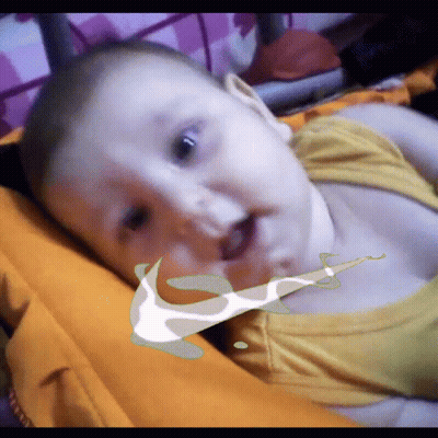 A Baby Is Laying On A Bed With A Nike Logo On Its Face GIF