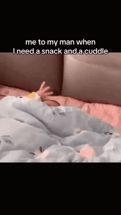 a baby is laying on a bed with the caption " me to my man when i need a snack and a cuddle " .