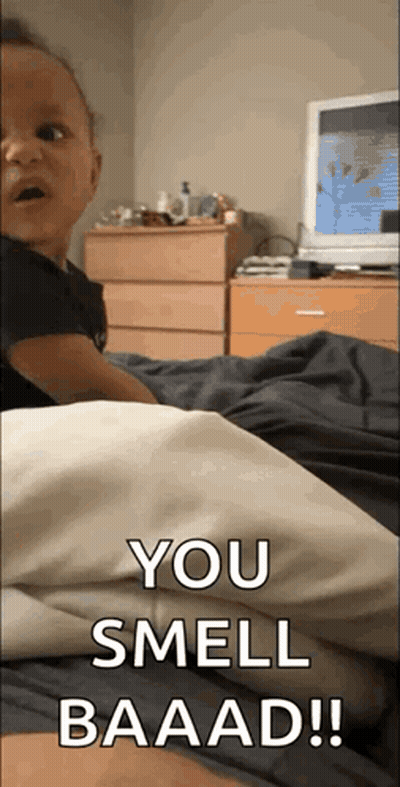 A Baby Is Laying On A Bed With The Words You Smell Baaad Written On The Bottom GIF