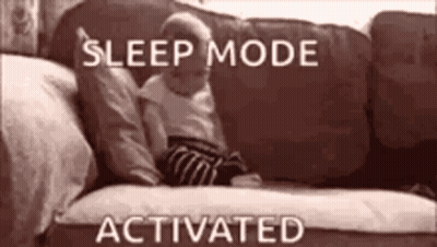 A Baby Is Laying On A Couch With The Words `` Sleep Mode Activated '' Above It . GIF