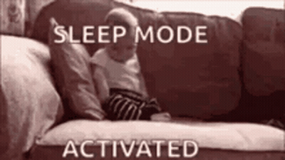A Baby Is Laying On A Couch With The Words `` Sleep Mode Activated '' Written Above It . GIF