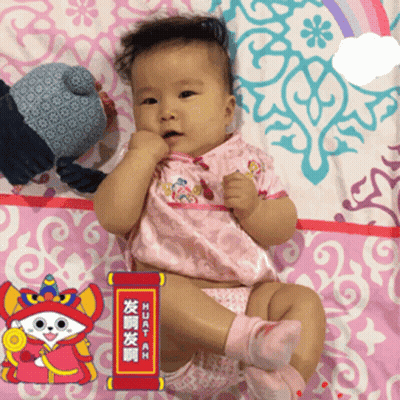 A Baby Is Laying On A Pink Blanket With A Sign That Says Huatah On It GIF