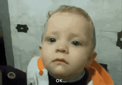 A Baby Is Making A Funny Face And Says `` Ok '' . GIF