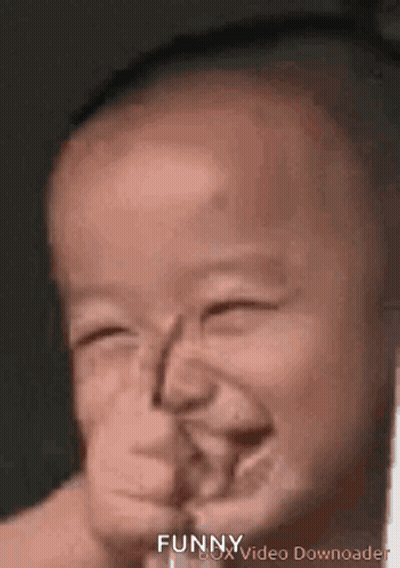 A Baby Is Making A Funny Face With His Eyes Closed And His Mouth Open . GIF
