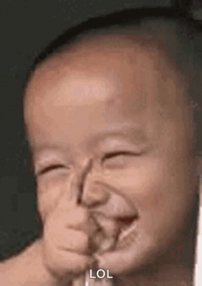 A Baby Is Making A Funny Face With His Hand In His Mouth And Laughing . GIF