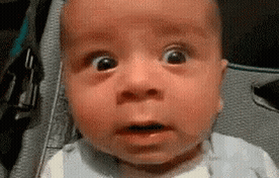 A Baby Is Making A Funny Face With His Mouth Open . GIF