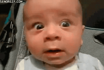 A Baby Is Making A Funny Face With His Mouth Open . GIF