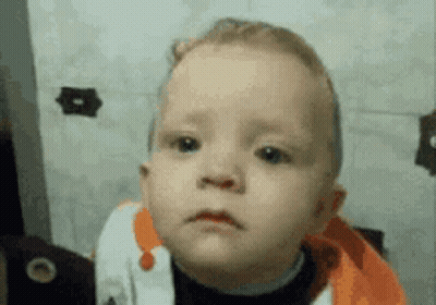 A Baby Is Making A Sad Face In Front Of A Mirror GIF