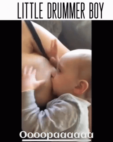 A Baby Is Nursing From A Woman 'S Breast With The Caption Little Drummer Boy GIF