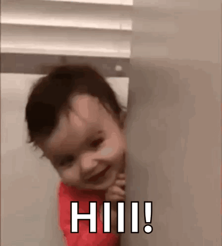 A Baby Is Peeking Out From Behind A Wall And Smiling With The Words Hi ! GIF