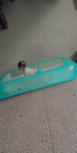 A Baby Is Playing In An Inflatable Pool GIF