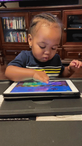 A Baby Is Playing On A Tablet With A Case On It GIF