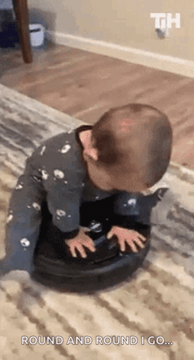 A Baby Is Playing With A Vacuum Cleaner On A Carpet . GIF