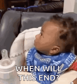 A Baby Is Sitting In A High Chair With A Bib On And A Bottle . GIF