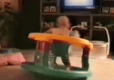 A Baby Is Sitting In A Rocking Chair In Front Of A Tv GIF