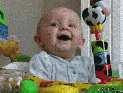 A Baby Is Sitting In Front Of A Table With Toys And The Website 4Gifs.com Is Visible GIF