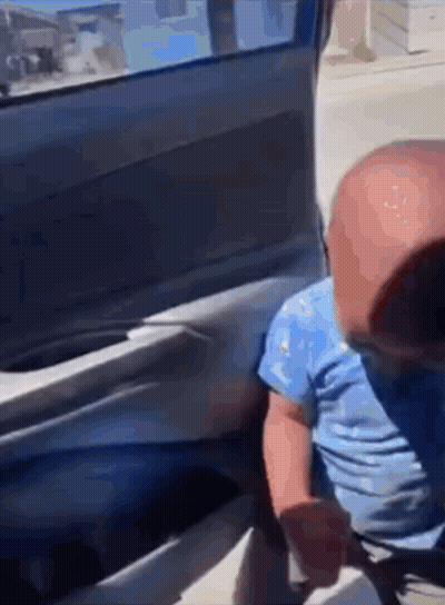 A Baby Is Sitting In The Back Of A Car . GIF