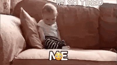 A Baby Is Sitting On A Couch With The Words `` I 'M So Tired '' Written Above Him . GIF