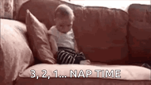 A Baby Is Sitting On A Couch With The Words `` Nap Time '' Written On The Couch . GIF