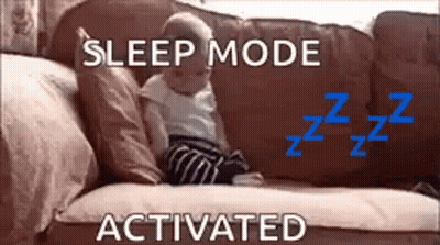 A Baby Is Sitting On A Couch With The Words `` Sleep Mode Activated '' Above It . GIF