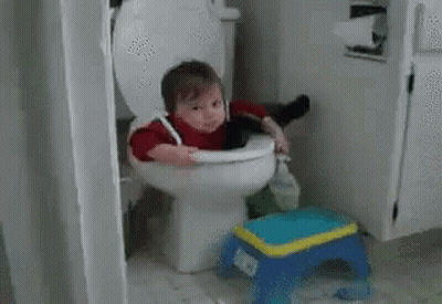 A Baby Is Sitting On A Toilet With A Broom In His Hand . GIF