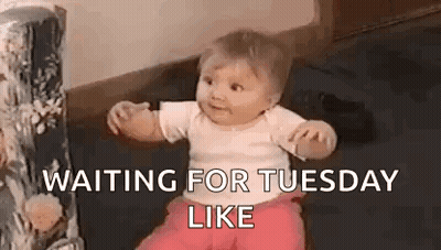 A Baby Is Sitting On The Floor With The Words `` Waiting For Tuesday Like '' Written On It . GIF