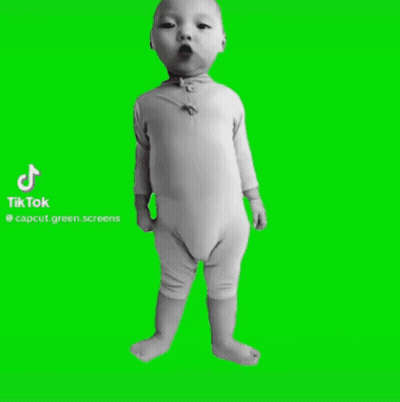A Baby Is Standing In Front Of A Green Screen . GIF