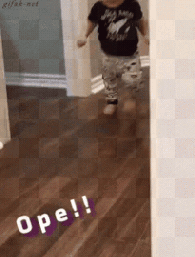 A Baby Is Walking On A Wooden Floor And The Word Ope Is On The Floor GIF