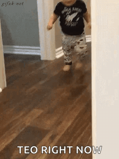 A Baby Is Walking On A Wooden Floor With The Words Teo Right Now Written On The Floor . GIF