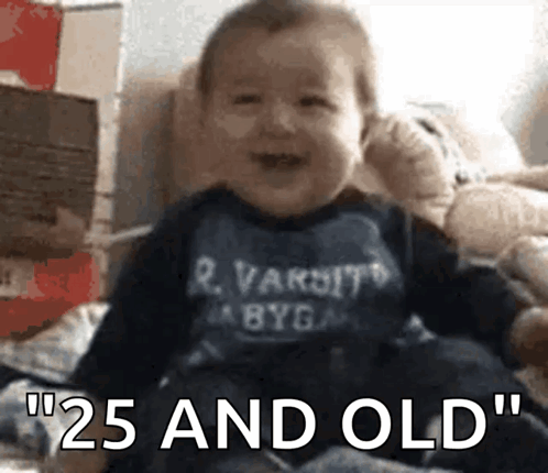 A Baby Is Wearing A Shirt That Says Varsity GIF