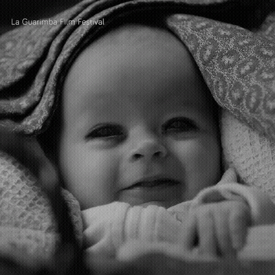 A Baby Is Wrapped In A Blanket With La Guarimba Film Festival Written On The Bottom Right GIF
