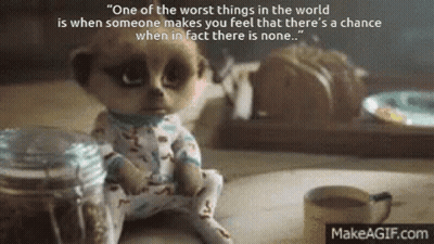 A Baby Meerkat Is Sitting On A Table Next To A Cup Of Coffee And A Jar . GIF